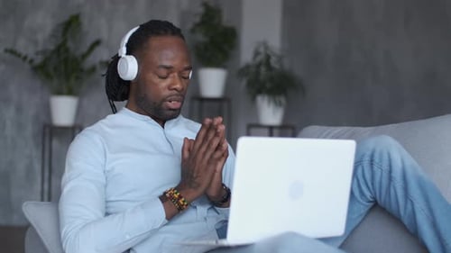 Man Video Conferencing on Laptop While Relaxing