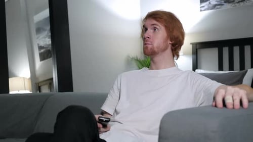 Young Man Watches Television on Couch