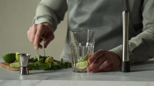 Preparing a Refreshing Drink with Lime and Mint