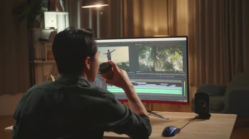 Asian Male Video Editor Works And Drinking Coffee With His Personal Computer