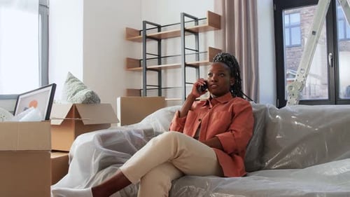Woman on Phone in Living Room with Boxes