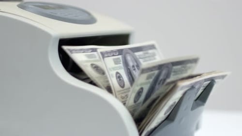 Money Counter Machine Processing Stacks of Dollar Bills