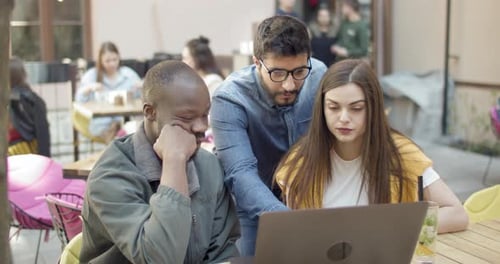 Team Looking at a Laptop in Urban Cafe