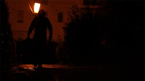 Man Carrying Bag in the Dark