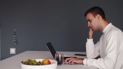 Thoughtful Serious Young Man Student Writer Sit at Home Office Desk with Laptop Thinking of