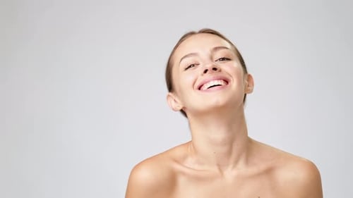 Young Woman Laughing with Clean Skin and Ponytail