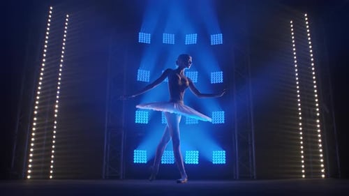 Elegant Ballerina Dancing on Stage with Blue Lights