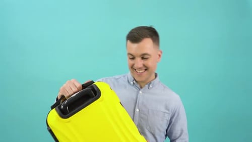 Smiling Man Holding Yellow Suitcase for Vacation