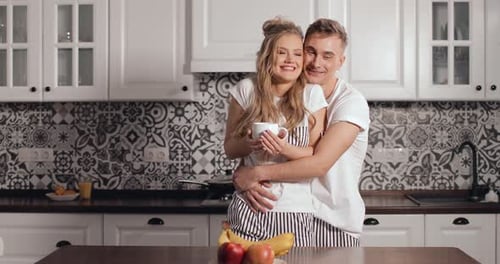 Affectionate Couple Embracing in Modern Kitchen