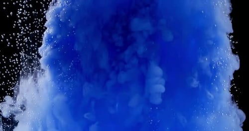Des nuages d'encre bleue se propagent dans l'eau, de petites bulles d'air et de la fumée colorée se répandent