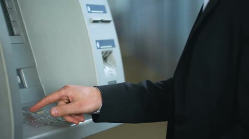 Kunde genervt bei der Arbeit am Geldautomaten, Karte bleibt in der Maschine stecken, Ausfall des Bankensystems