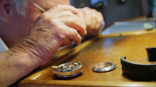 Nahaufnahme eines Uhrmachers, der eine Uhr repariert