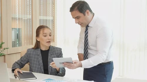 Business People Discussing Data on Tablet in Office