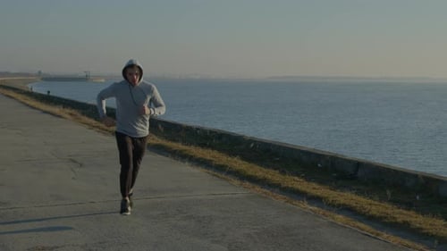 Young Man Is Running Near Lake