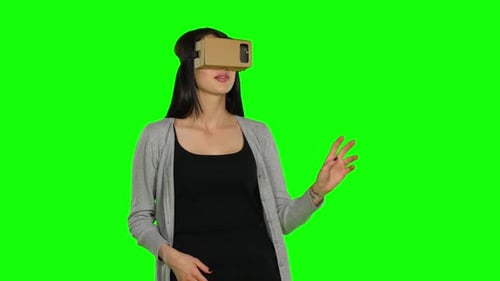 Girl in Virtual Reality Is Smilling and It Makes Him Laughing. Green Screen