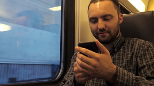 Handsome Man Sitting in A Subway Train and Surfing in Web