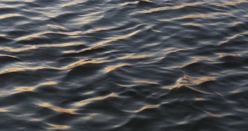 Stetige Aufnahme von Donauwasser mit Lichtreflexen bei Sonnenaufgang