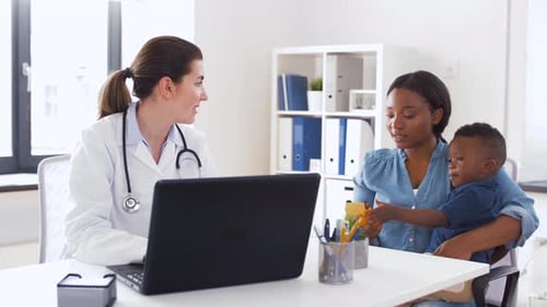 Mutter mit Baby und Arzt mit Laptop in der Klinik