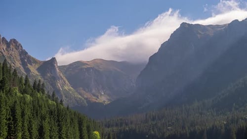 Time Lapse Shot Mountains Peaks Mountain Range Covered with Rolling Clouds in Blue Sky Sun Light