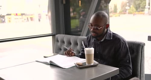Young Black Businessman Drinking Latte on the Terrace