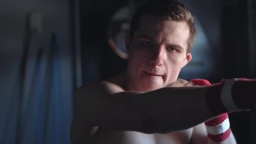 Junge attraktive MMA-Kämpferin schaut in die Kamera und schattiert dann Boxen in Zeitlupe PORTRAIT