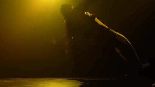 Silhouette of a Talented Young Break Dancer. Hip Hop Street Dance on a Stage in Front of the