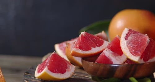Pink Grapefruit Sections in Wooden Bowl on Table