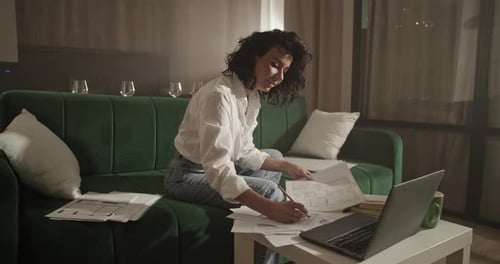 Woman Working with Blueprints at Home