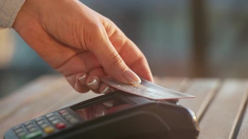 Customer Swiping Card on POS Terminal Close Up