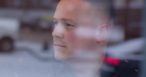 Young Man Writing Seen Through Cafe Window