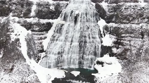 Waterfall Dynjandi during the winter with snow in North West Iceland