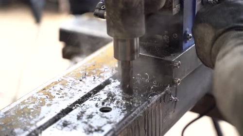 Bohren von Löchern in Eisenprofil mit Industriemaschine.
