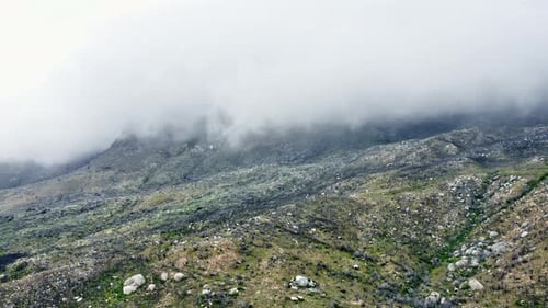 Aerial Shot of the Lush Mountains and Fog Covering the Top Area of Frame