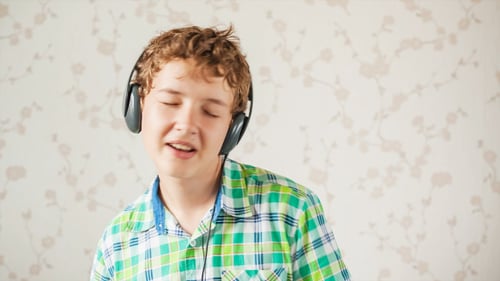 The Teenager Boy Listens to Music