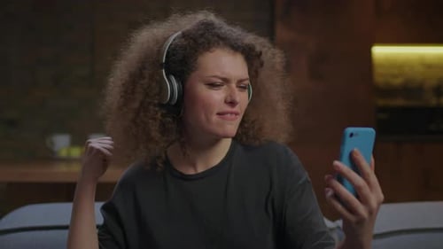 Woman with Headphones Singing into Smartphone
