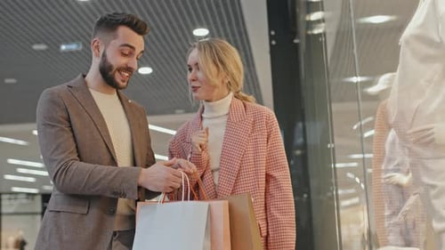 Young Couple Shopping at Brightly Lit Urban Mall