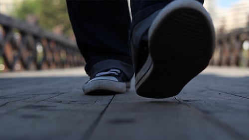 Person Walking on a Wooden Bridge in the City