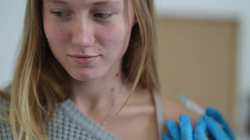 Closeup Portrait of Teenage Caucasian Girl Getting Covid19 Vaccine Shot in Vaccination Center