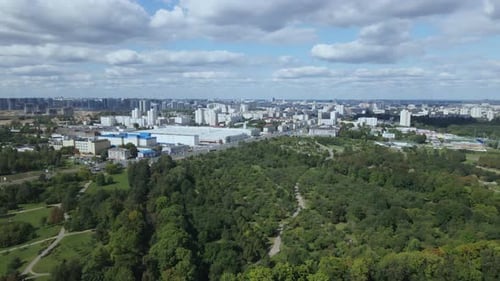 City landscape. Nearby there is a park area. Blue sky with white clouds. Aerial photography.