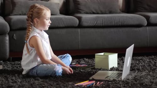 Child Sits With Laptop at Home