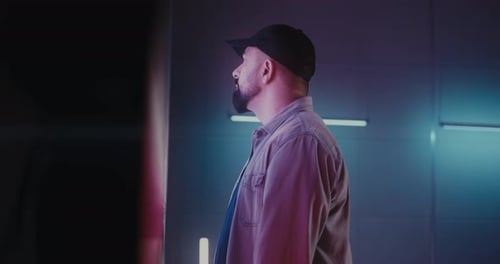Man Touches Illuminated Panel in Futuristic Room