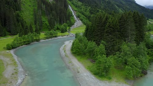 Aerial Fly Along Mountain River with Blue Water and Beautiful Waterfall in Background