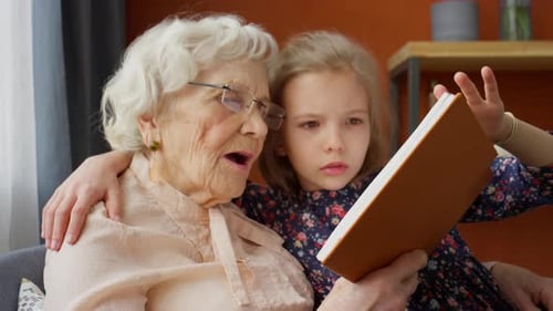 Grandmother and Child Reading Book Together Indoors