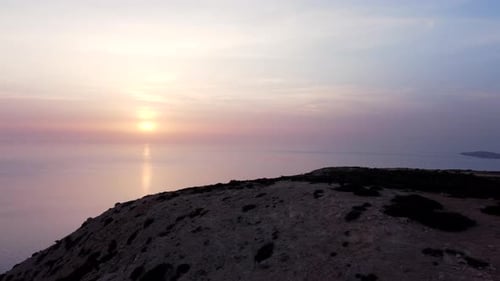 Aerial view of a couple on a mountain peak at sunset. Freedom or hiking concept