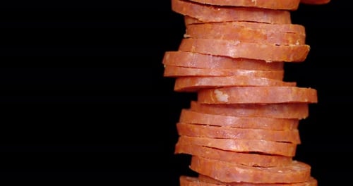 Stacked Pepperoni Slices on Black Background