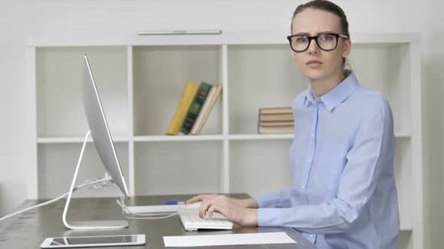Confused Woman Working at Computer in Office
