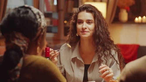 Woman Eating and Talking with Friends Indoors