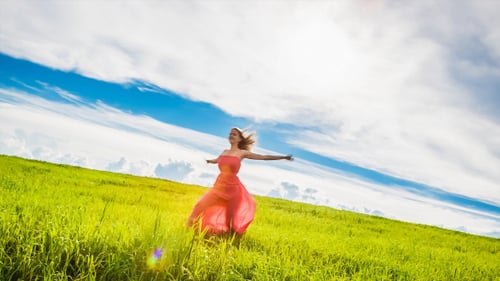 Young Woman Runs Across the Meadow