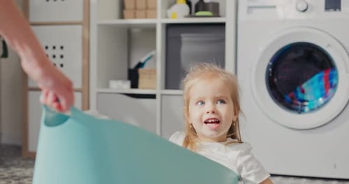 Cute Girl Inside Laundry Tub in Bright Home