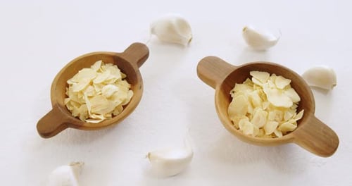 Raw Garlic Slices in Small Wooden Bowls